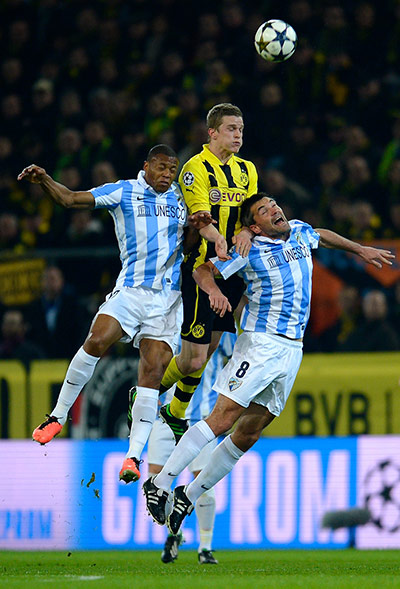 Dortmund v Malaga:  Sven Bender heads clear from Baptista  and Jeremy Toulalan
