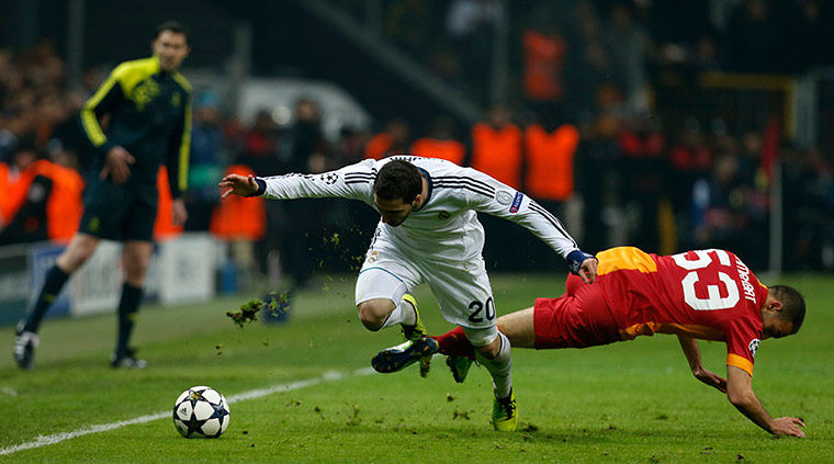 Galatasary versus Madrid: Galatasaray's Nordin Amrabat challenges Real Madrid's Gonzalo Higuain 