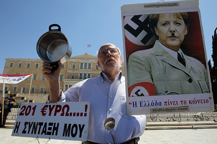 May Day: An elderly man holds a poster with a picture of Angela Merkel