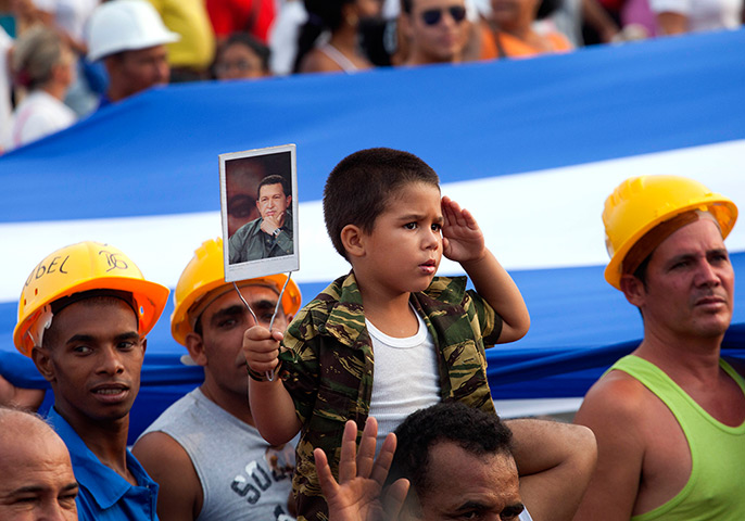 May Day afternoon: A boy salutes as he holds up an image of Hugo Chavez in Havana, Cuba