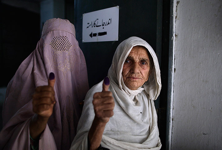 Pakistan: Voters show their election ink-stained thumbs after casting their ballots