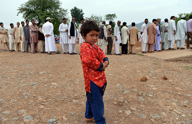 Pakistan: A young Pakistani child plays in front o