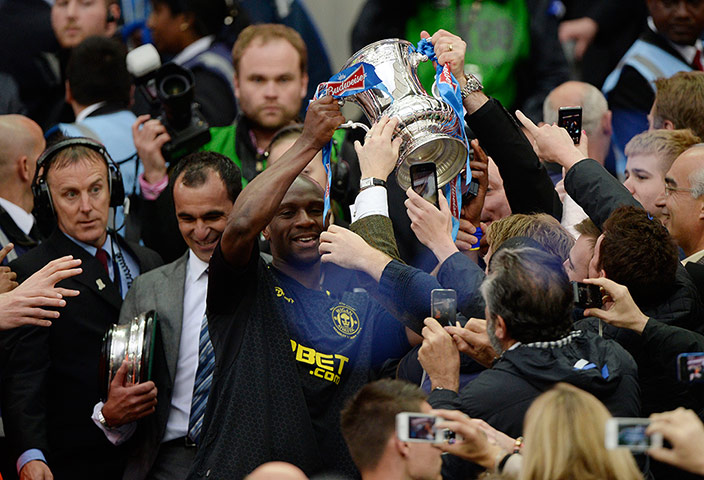 TJ Cup Final 4 : Wigan captain Emmerson Boyce carries the FA Cup down from the Royal Box