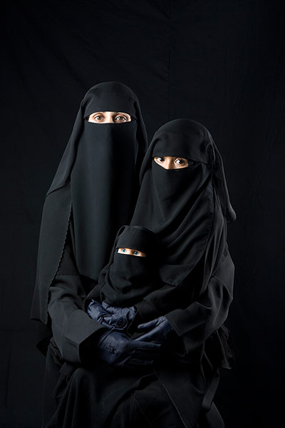 big picture - hijab: middle eastern woman wearing full black hijab holding child and doll