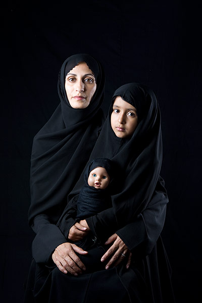 big picture - hijab: woman dressed in black hijab with child and doll