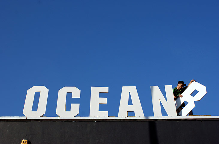 Your Pictures - skylines: man removing r letter from ocean signage