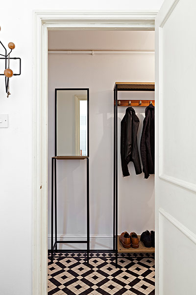 Homes - Pettersen: white hallway with diamond patterned floor and jackets on rails