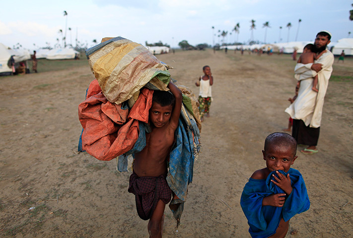 Cyclone Mahasen: A boy carries plastic sheets to use as shelter at a camp outside Sittwe