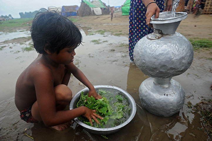 Cyclone Mahasen: A Rohingya boy washes vegetables at a camp
