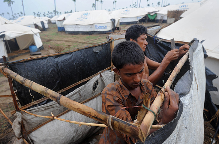 Cyclone Mahasen: A Rohingya man fixes his tent at a camp