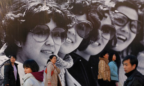 Chinese pedestrians in front of black and white picture