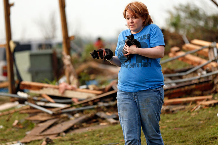 Rachel Hilton carries kittens she found in the debris of her parents' home