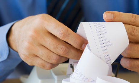 Businessman looking at adding machine tape