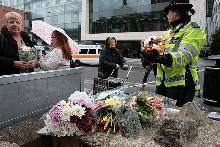 Woolwich response: A police woman takes a floral tribute in Market Street