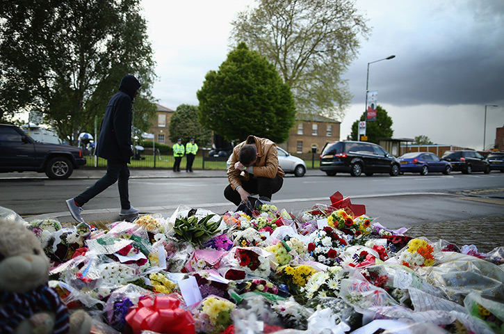 Woolwich response: A man contemplates at a scene where flowers lay, outside Woolwich Barracks