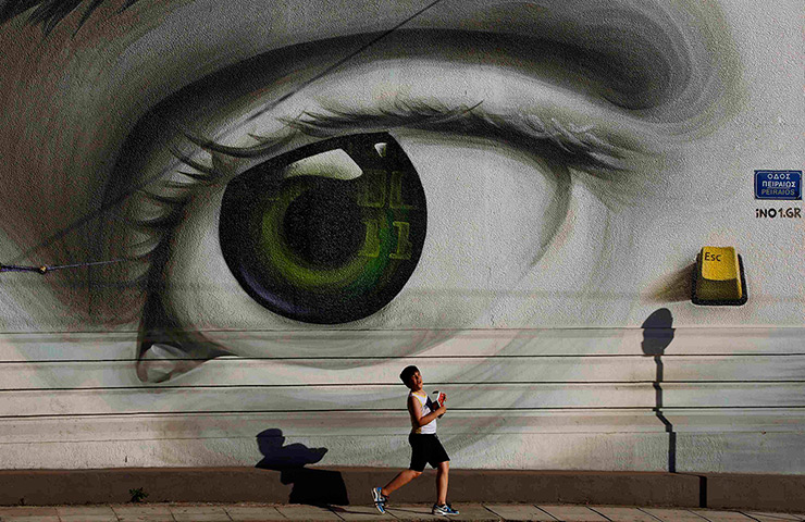 24 hours: Athens, Greece: A boy walks past graffiti in the Tavros neighbourhood 