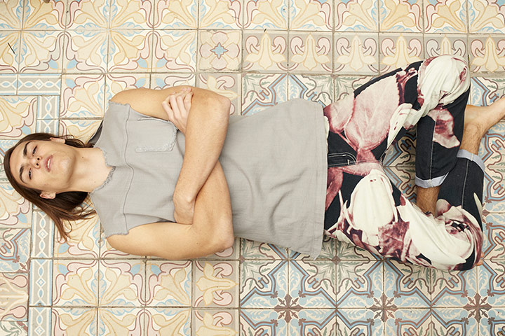 Fashion - Men's Print: Male model lying on tiled floor wearing print jeans and grey top