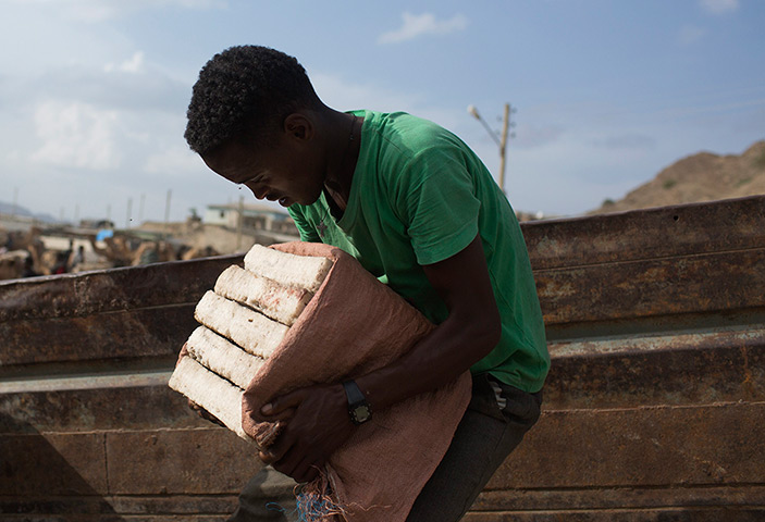 FTA: Siegfried Modola : A man lifts slabs of salt onto a truck in the town of Berahile in Afar, nor