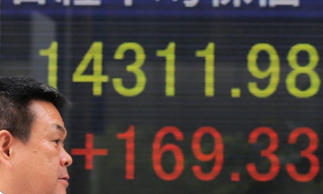 A man walks by an electronic stock board of a securities firm in Tokyo, Tuesday, May 28, 2013.