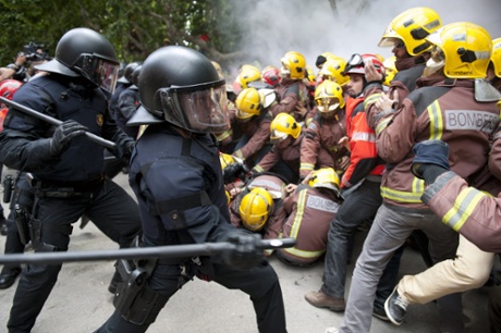 Riot police try to stop the entrance to the Catalonia Parliament at firemen protesting for sector budget cut in Barcelona.