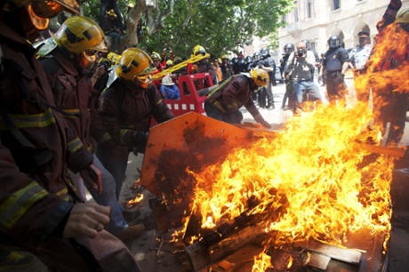 Firemen burned coffins that symbolized the death of the public services due to austerity measures in front of the Catalonia Parliament.