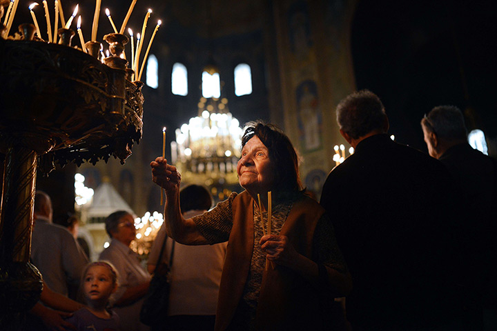 24 hours in pictures: A Bulgarian woman lights a candle during the Good Friday s