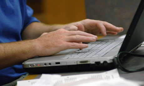 Man's hands typing on laptop.