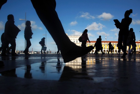 Commuters walk along Comercio square during a 24-hour subway workers strike, Lisbon, Thursday, May 30, 2013.