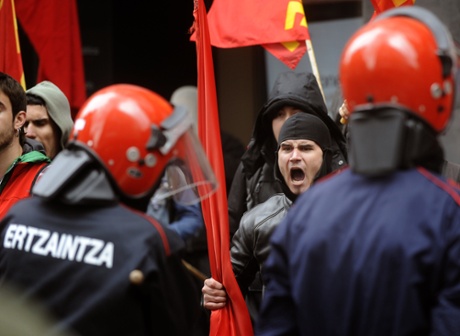 Members of union picket lines protest with Basque policemen at the entrance of a shopping mall during a regional strike called by the main Basque unions in the northern Spanish Basque city of Bilbao, on May 30, 2013.