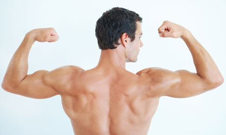 Rear view of handsome man flexing biceps on white background