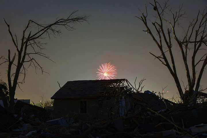 20 Photos: fireworks explode far above a house damaged by a tornado in Moore, Oklahoma