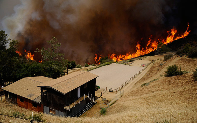 California wildfire: Fire races through the canyons