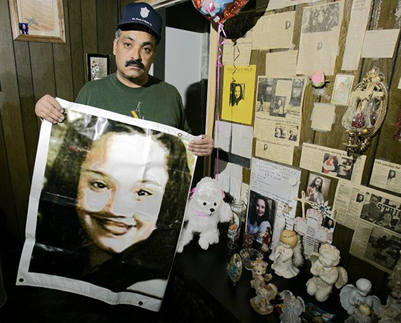 ohio missing: Felix DeJesus with a missing person poster for his daughter, Gina, in 2004