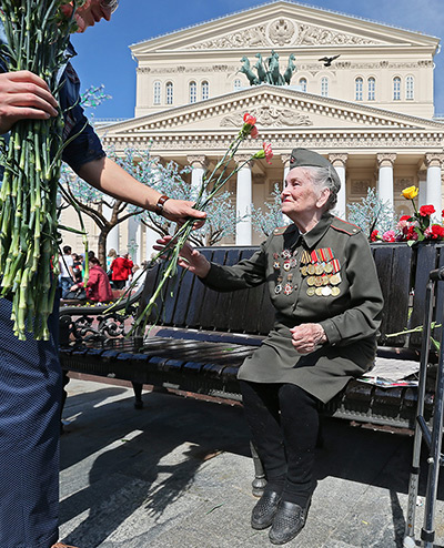 Victory day celebrations: A medalled Russian WWII woman veteran accepts flowers