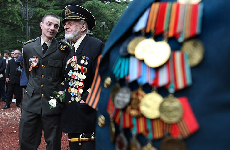 Victory day celebrations: A Georgian military cadet speaks with a WWII veteran at a WWII memorial dur