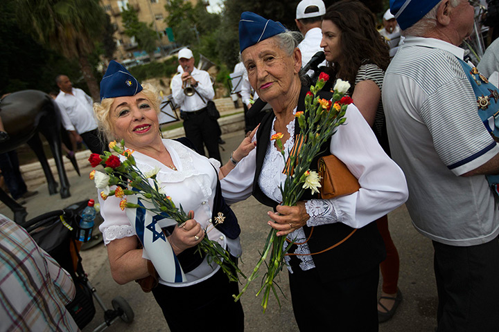 Victory day celebrations: Israeli women hold flowers as they wait for the start of a parade marking V