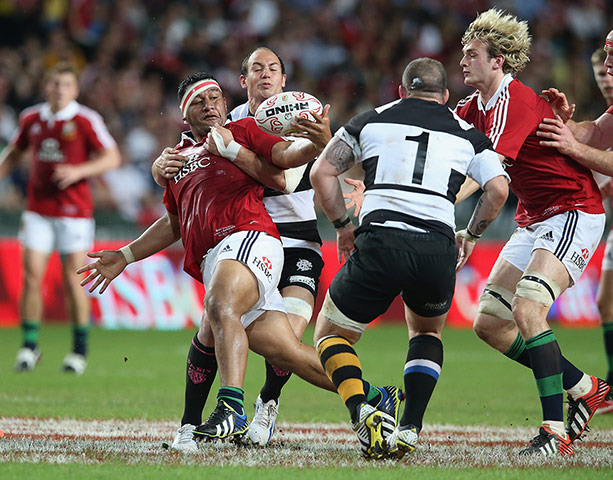 lions: Mako Vunipola is tackled by Elliot Daly