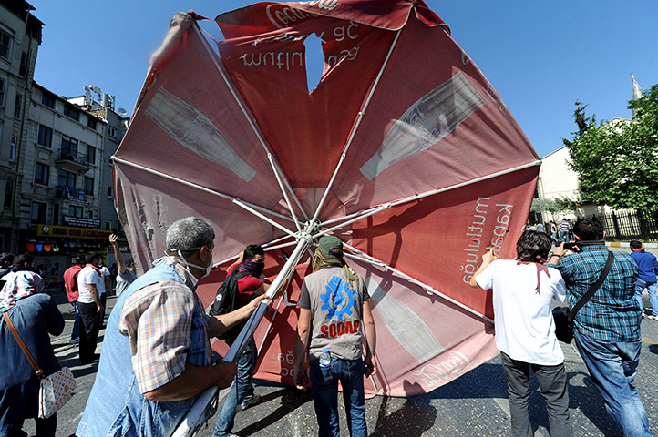 Saturday rioting: Turkish protestors prop up a large umbrella