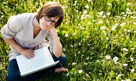 Woman with laptop in wild meadow
