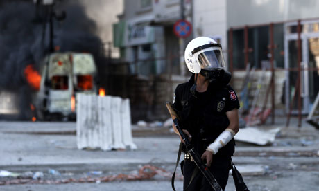 A Turkish riot policeman holds a tear gas grenade launcher in Taksim Square