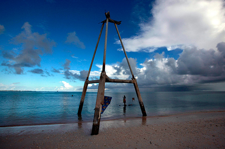 Kiribati, Pacific island: Binata Pinata stands on top of a rock underneath an old tower. The tower us