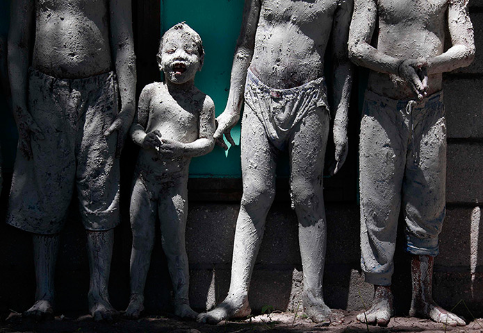 Kiribati, Pacific island: A boy covered in reef-mud stands with other boys in the village of Ambo