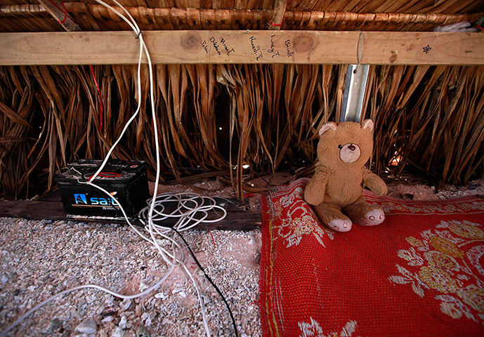 Kiribati, Pacific island: A toy bear sits next to a battery storing solar power in the home of Binata