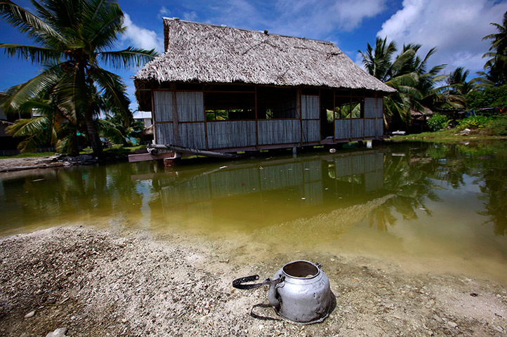 Kiribati, Pacific island: An abandoned house that is affected by seawater during high-tides stands ne