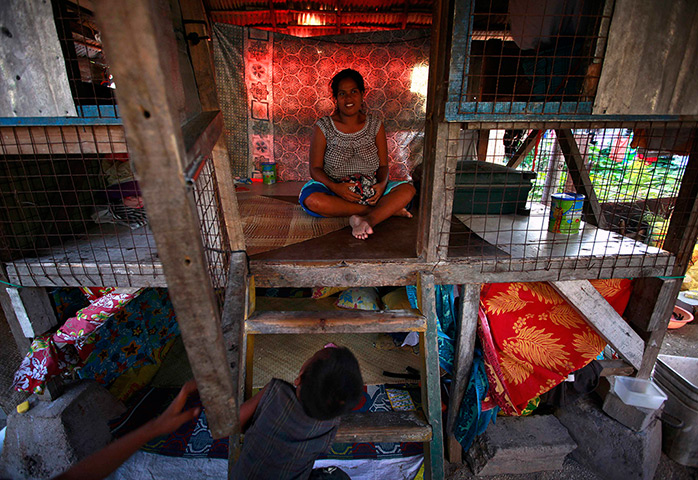 Kiribati, Pacific island: A pregnant woman sits inside her small hut in the village of Betio