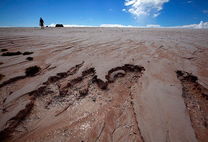 Kiribati, Pacific island: Shifting sands are seen as Kaibakia Pinata walks from his huts to cast his 