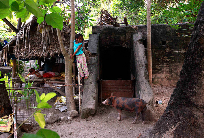 Kiribati, Pacific island: A girl stands on a World War Two Japanese bunker, which is being used as a 