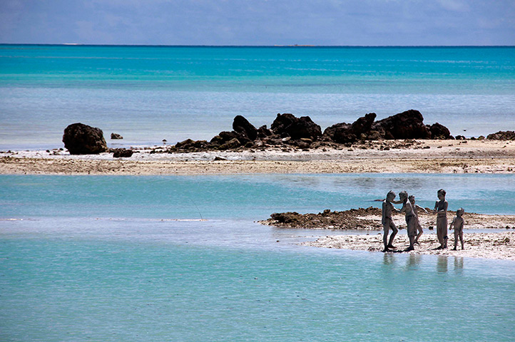 Kiribati, Pacific island: Young boys cover each other in reef-mud