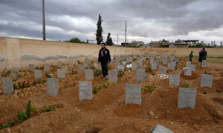 Men visit the graves of people whom activists say were killed by forces loyal to Assad, in Qusair 