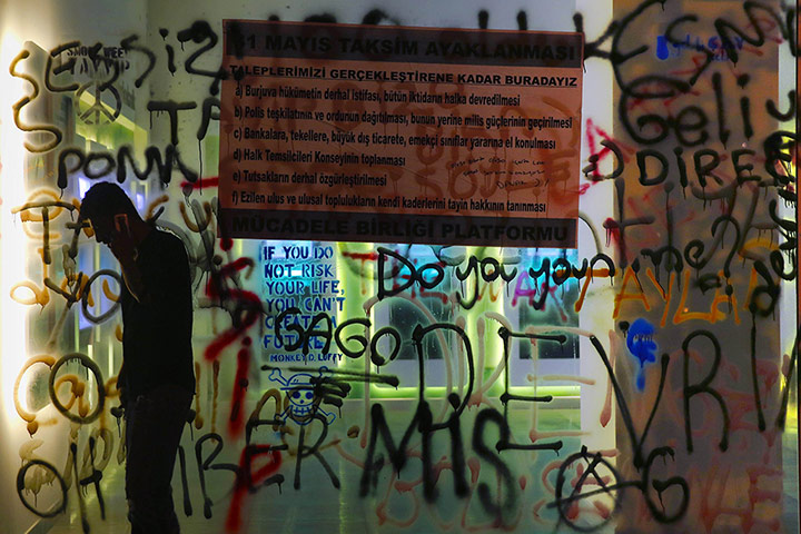 20 Photos: A protester in front of a shop window painted with graffiti in Istanbul